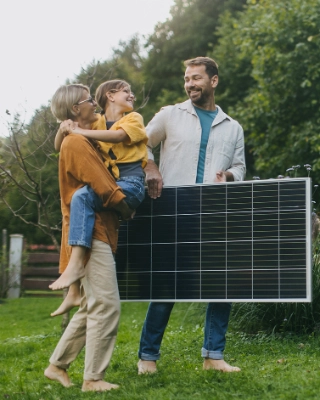 Familie vor Ihrem Eigenheim mit einem Solarpanel.